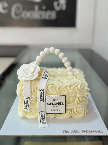 We designed this elegant cake to look just like a classic Chanel handbag. The delicate buttercream rosettes and edible pearl handle showcase our detailed piping and sculpting work for a sophisticated celebration.