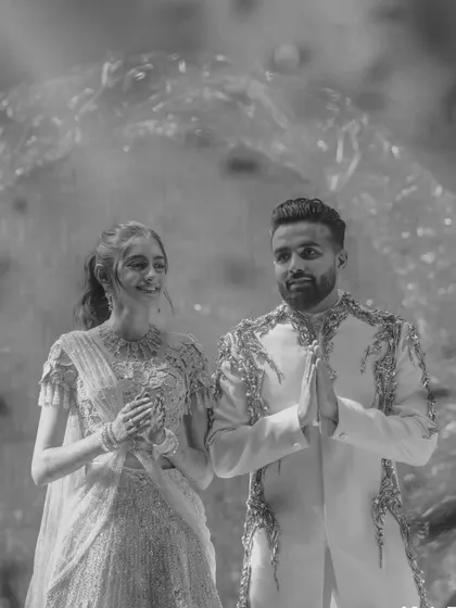A timeless black and white shot of the couple's entrance. Even without color, the joy and elegance of the moment shine through, a testament to classic style.
