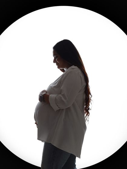 A simple and beautiful silhouette of the mother-to-be, focusing on the classic profile of her baby bump.
