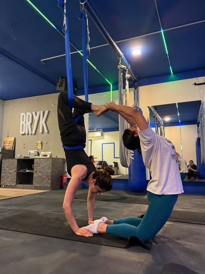 Partner work is a great way to build trust and strength. Here, two members create a beautiful, balanced shape, supporting each other through the pose.