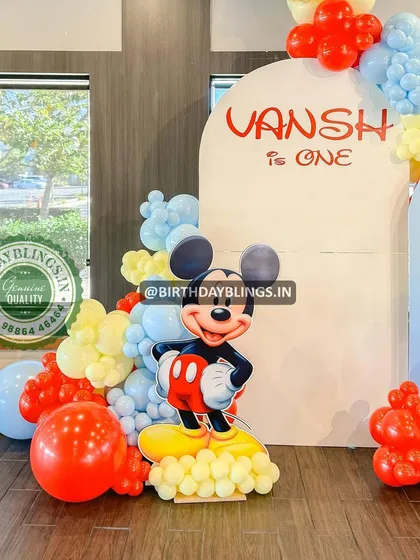 A close-up of the Mickey Mouse first birthday setup, showing the character cutout and the personalized backdrop.