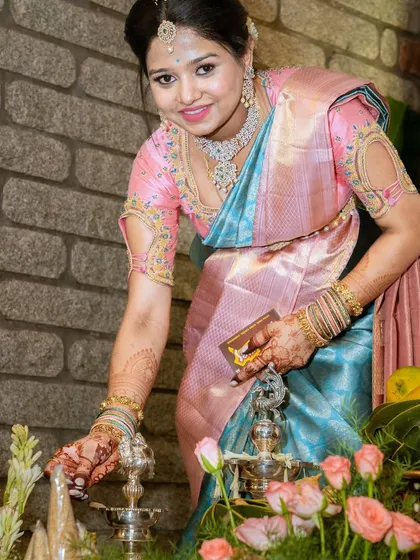 Lighting the lamp, a sacred ritual. Monika performs the tradition with grace in her elegant silk saree.