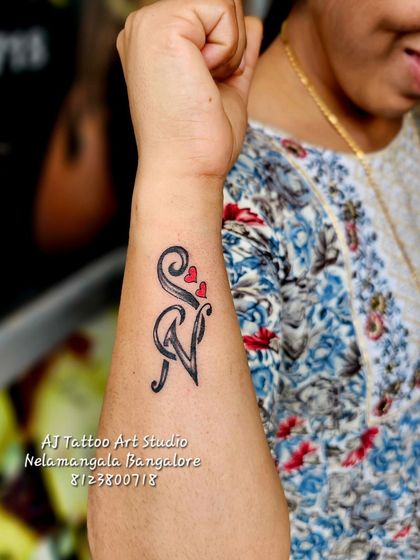 A creative design intertwining the initials 'S' and 'N' with small red hearts.