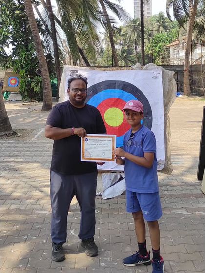This young archer is all smiles after getting his certificate for completing the summer camp.
