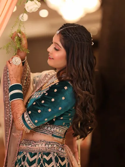 A side profile of the bride, showing how the soft makeup and intricate hairstyle come together. The focus is on her glowing skin and happy expression.