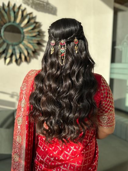 The hairstyle for the engagement featured soft waves and a half-up style, adorned with beautiful traditional hair accessories that added a touch of sparkle to the look.