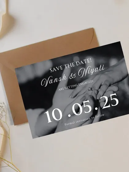 A classic and timeless Save the Date card. It features a beautiful black and white photograph of the couple's hands, capturing the intimate moment of the ring exchange. The simple, elegant typography lets the moment speak for itself.