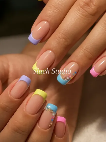 A playful and modern twist on a classic. These square French tip extensions feature a different pastel color on each nail, with small floral gem details on the accent nails for a fun, summery vibe.