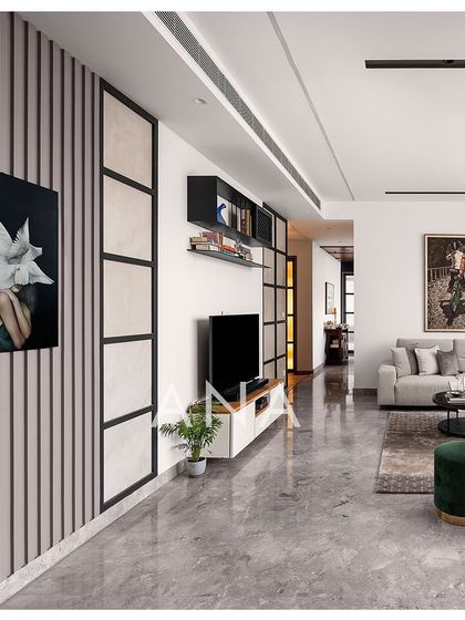 The TV wall in Apartment 704 features vertical fluted panels and a clean, low-profile cabinet. The design maintains the minimalist aesthetic while adding subtle texture and visual interest.