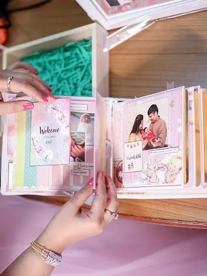 A close-up of the client flipping through the pages of the baby album, reliving each precious memory.