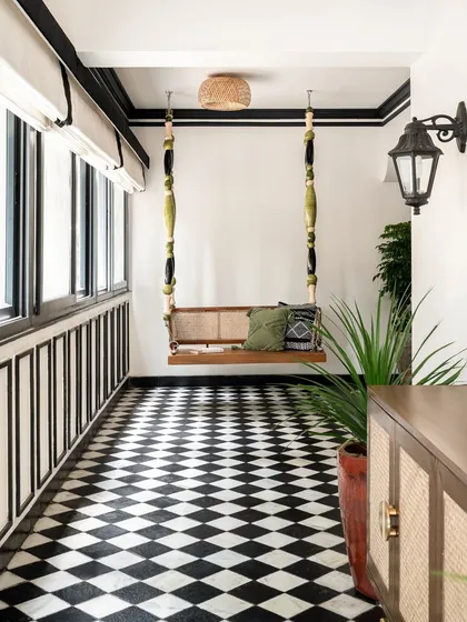 We love creating playful and unexpected moments. This custom swing, made with a cane seat and sculptural lacquered wood beads, transforms a simple corridor into a charming nook, set against classic black-and-white checkerboard flooring.