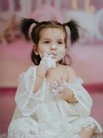 A happy, cake-covered smile. This image is the essence of a fun and successful first birthday cake smash.