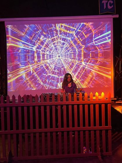 A wider view of the unique DJ setup at Cafe TC, with a wooden picket fence separating the booth from the dance floor.