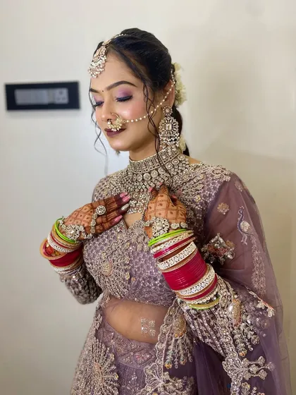 This photo shows how the right nail art completes the entire bridal look. The client is wearing a beautiful lavender lehenga, and I designed her nails with a matching mauve polish and glitter accents. The nails look elegant and cohesive with her jewellery and mehendi.