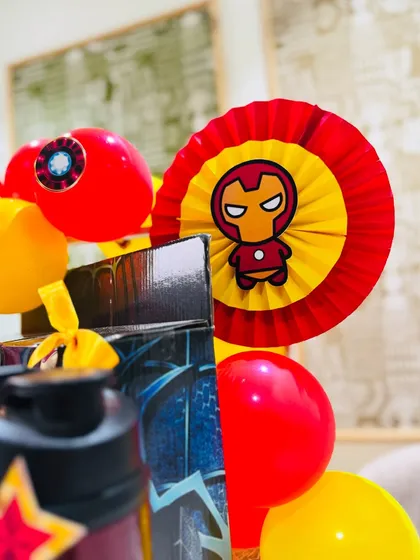 Themed paper fans and balloon details, all in Iron Man's signature red and gold, complete the look of this epic kid's hamper.
