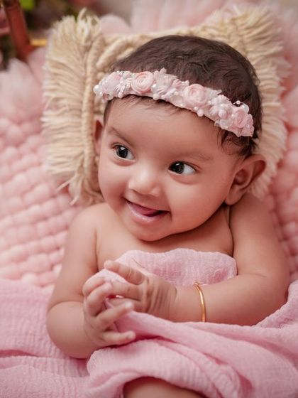 A smile that melts my heart. This older baby is full of joy, and the soft pink setup is the perfect match for her sweet personality.