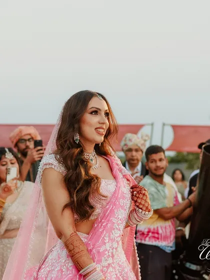 A beautiful candid of the bride during her entry. Surrounded by guests capturing the moment, her radiant smile is the center of attention.