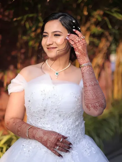 A close-up of the Christian bride's look, showing the delicate balance between her intricate henna and the classic elegance of her white gown and natural makeup.