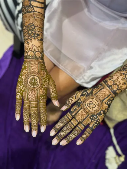 One hand features a beautiful Ganpati design for blessings, while the other has the couple's monogram. It's a perfect blend of sacred and personal elements.