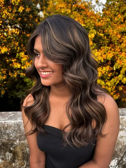 A beautiful shot of the balayage created during my Surat masterclass, with the warm tones of the hair complementing the autumn-colored background.
