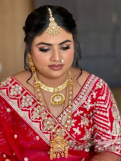 A close-up of the bride's glamorous red bridal look. The smoky eye and perfectly sculpted brows add a touch of drama, while the skin remains radiant.