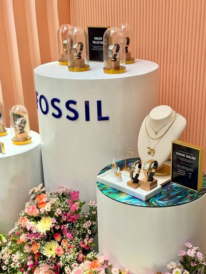 This product display for Fossil showcases our expertise in creating elegant retail-like setups for events. We combined branded pedestals, glass cloches, and lush floral arrangements to highlight the watches and jewelry collections.
