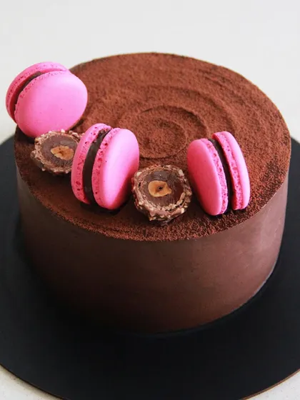 One of my signature designs and most popular flavors. This chocolate cake is topped with Ferrero Rocher and vibrant pink macarons.