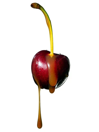This image captures a perfect, slow drip of caramel from a fresh cherry. The clean white background and sharp focus make this a minimalist yet highly appetizing shot from my fruit and liquid series.