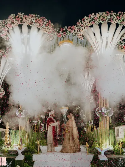 A cinematic shot of the couple's varmala, enveloped in a cloud of smoke. These special effects are timed perfectly to create dramatic and unforgettable photographs of your key moments.