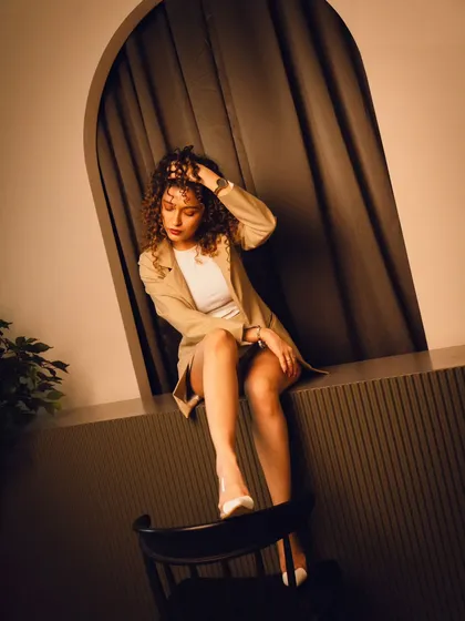 A creative and dynamic pose that uses the furniture and architecture of the room in a unique way.