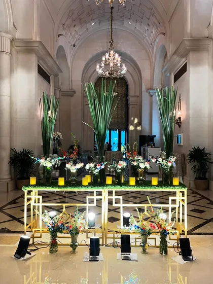 An elegant floral and candle display in the grand corridor of The Leela Palace, guiding guests to the main event hall.