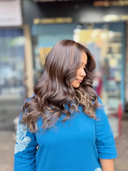 A soft blonde hair color achieved without bleach. This look adds gentle, warm highlights to a dark base for a subtle and natural-looking enhancement.