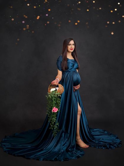 A beautiful full-length portrait in a satin teal gown. The basket of flowers adds a soft, natural element to this elegant studio shot.