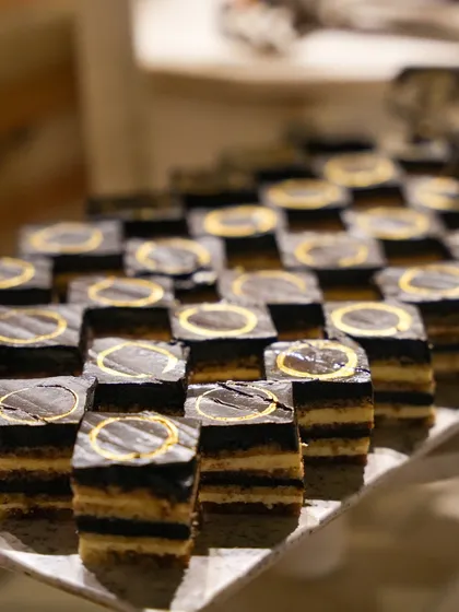 An army of perfectly uniform opera cakes, showcasing the precision and skill of our pastry chefs.