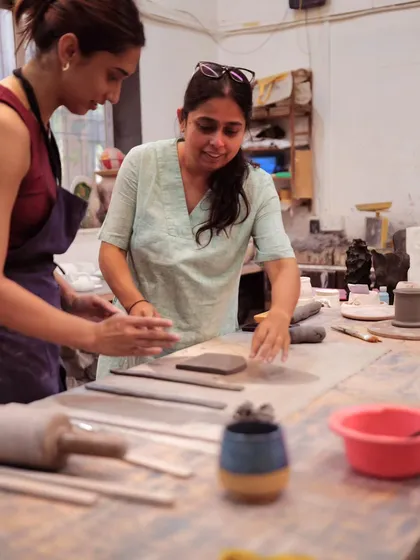 I’m Yashashri, and I’m here to guide you on your clay journey. In this photo, I'm helping a student with a hand-building technique, ensuring they feel comfortable and confident as they create.