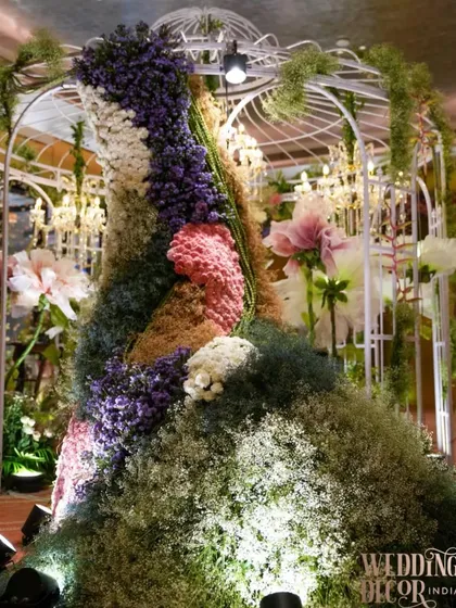 A magnificent floral sculpture of a gown, created for a pastel-themed engagement. This unique and artistic installation, made from thousands of flowers, served as a stunning and unforgettable centerpiece.
