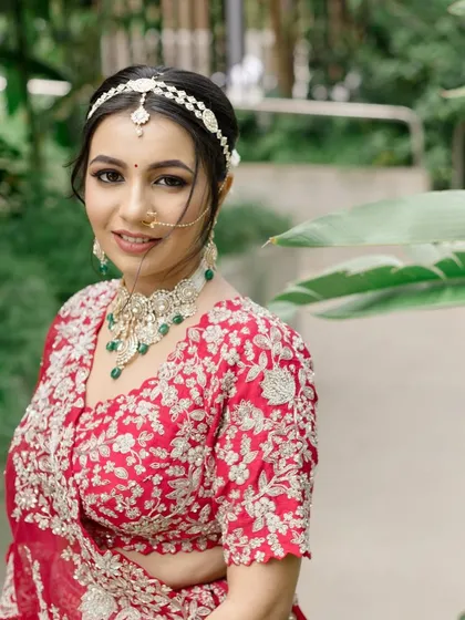 A close-up portrait that captures the bride's radiant smile and the beautiful details of her makeup and jewelry.