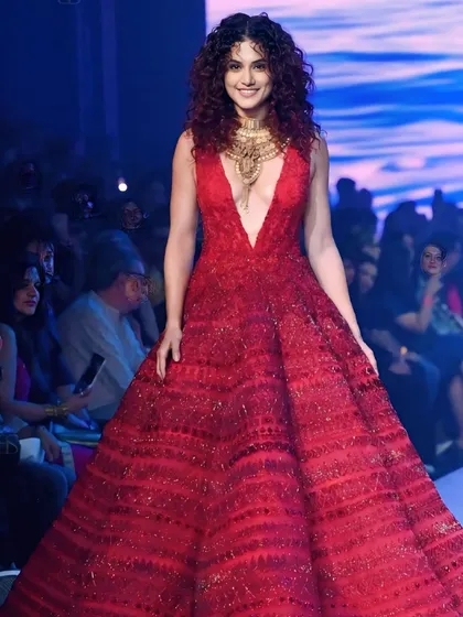 Taapsee Pannu makes a grand entrance at Lakme Fashion Week in a voluminous red gown. This shot captures the drama and scale of her showstopper outfit.