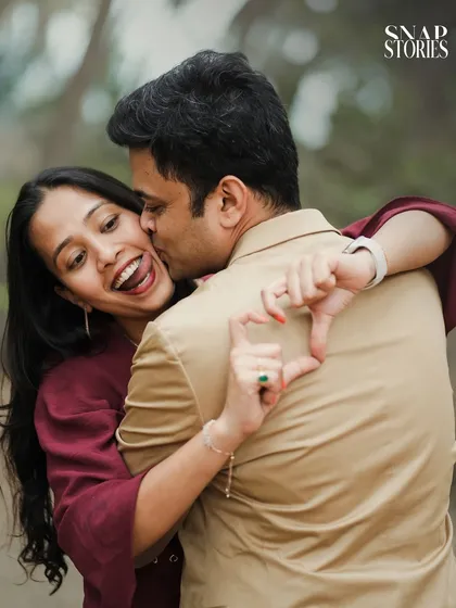 A fun and spontaneous moment captured during a walk in the park. The heart-shaped gesture adds a playful and personal touch to their pre-wedding photos.