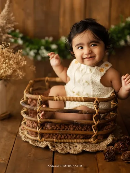 A moment of pure joy. This little one is having so much fun in this rustic basket setup, surrounded by natural props and greenery.
