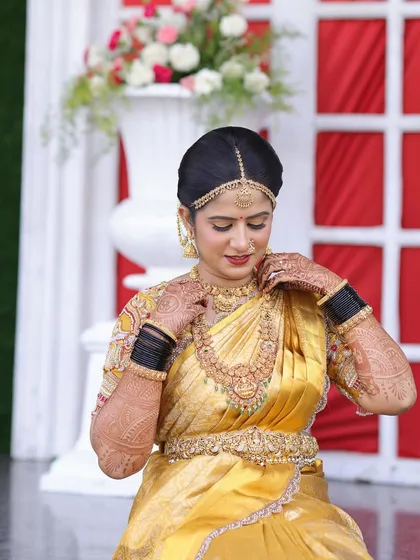 Rashmi getting ready for her Muhurtham. The golden-hued makeup and traditional jewellery are perfectly suited for the grandeur of a South Indian wedding ceremony.