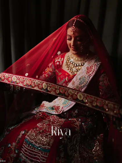 A beautiful portrait of the bride, Riya, under her veil. This classic shot captures her serene expression and the intricate details of her bridal look.