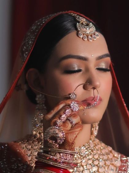 A close-up shot capturing the intricate details of the bridal makeup. The shimmery eyes, perfect nath, and radiant skin make this a favourite look of mine.