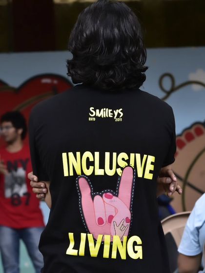 The back of our iconic 'Inclusive Living' t-shirt, featuring the 'I love you' sign. It's a symbol of our commitment to love, acceptance, and Deaf allyship.