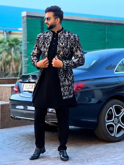 The black and silver Indo-Western sherwani, styled for a modern, sophisticated look. The intricate jacket is the centerpiece of the outfit.