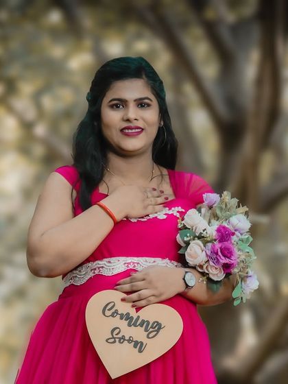 A sweet and simple solo portrait with a "Coming Soon" prop. The focus is on the mom-to-be's gentle smile and the heartfelt message, making for a lovely announcement.
