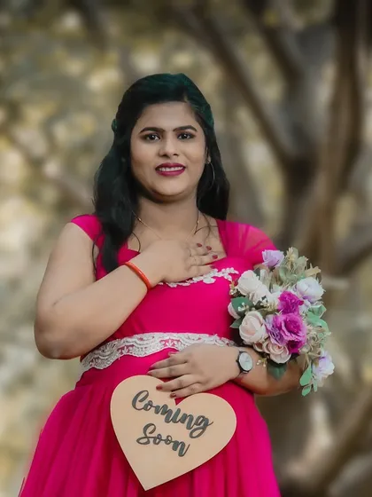 A sweet and simple solo portrait with a "Coming Soon" prop. The focus is on the mom-to-be's gentle smile and the heartfelt message, making for a lovely announcement.
