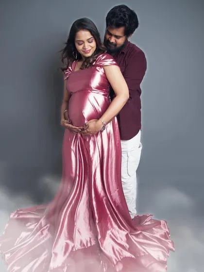 A dreamy couple's portrait with a soft fog effect at the bottom. The shiny pink gown and the loving embrace create a romantic and magical atmosphere.