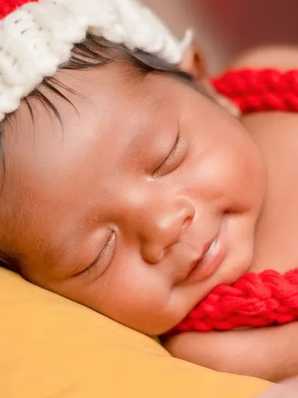 A beautiful close-up of a smiling newborn. It's rare to capture a smile, and it makes for an extra special memory from the 'Santa' photoshoot.