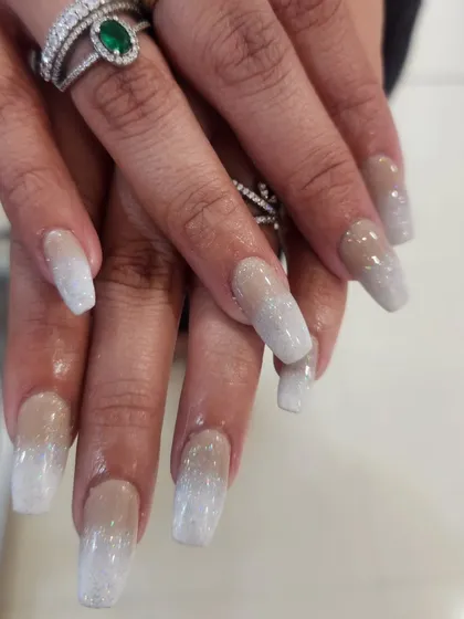 A flawless example of a classic favorite: nude and white glitter ombre nails. This elegant design on long square extensions shows a seamless blend of color and sparkle, perfect for any occasion.